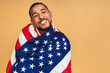 © denis_vermenko - Portrait of positive african american black guy holding usa flag, isolated over beige background.