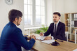 © Studio Romantic - Young man speaking to his lawyer. Concerned businessman asking for a law consultation. Professional attorney meeting with his client, sitting at his office desk with gavel, and listening attentively