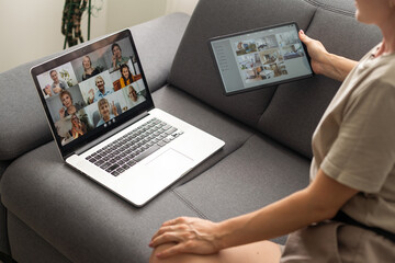 Wall Mural - Young woman enjoying video conversation via laptop with eldery mother while sitting on sofa during self isolation for coronavirus prevention.