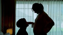 4K, Shadow Portrait Of Two Asian Women In Same-sex Couples.Both Showed Love, One Leaning Towards The Pregnant Woman's Belly And The Other Kissing His Forehead. Love And Friendship Of LGBTQ Couples
