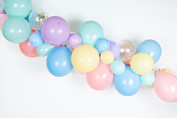 A close up image of a soft pastel balloon garland against a white background