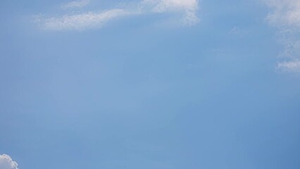 Wall Mural - Low angle shot of blue sky with white clouds. Fluffy white clouds nature. Cumulus cloud passing by in timelapse. Majestic amazing blue sky.