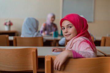 Wall Mural - Happy Muslim school girl during the class in the classroom.	