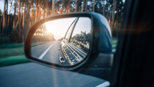 Road Trip Car Mirror. Sun, Highway Car Road Reflection In Mirror. Summer Holidays Trip Concept.
