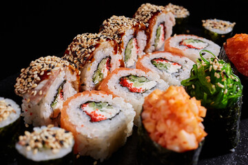 Sticker - Japanese cuisine. Close up of delicious sushi rolls with various fillings on dark background.