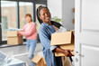 © Syda Productions - moving, people and real estate concept - happy smiling women with boxes at new home