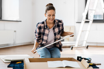 Wall Mural - repair, improvement and furniture concept - happy smiling woman with manual assembling new locker at home