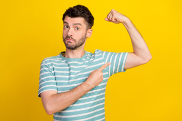 Sticker - Photo of young attractive sporty man showing his biceps hobby after work fit serious isolated on bright yellow color background