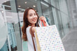 © Kiattisak - Beautiful asian female woman girl holding shopping bags, Walk enjoy smiling while doing shopping outside of department store malls window outdoors fashion lifestyle