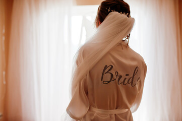 Poster - Wedding day preparation. Bride wearing a white bridal bathrobe.