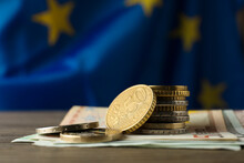 Coins And Banknotes On Wooden Table Against European Union Flag, Space For Text
