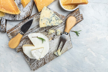 Wall Mural - Various types of cheese Piece of Parmesan cheese, dor blu, camamber brie with knife on a light background. top view