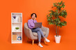 Leinwandbild Motiv Full size photo of busy girl sit armchair speak telephone buy house interior isolated on orange color background