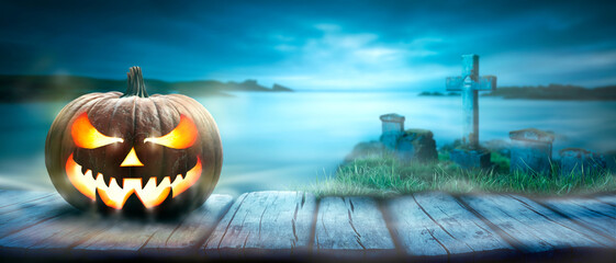 Wall Mural - one spooky halloween pumpkin, jack o lantern, with an evil face and eyes on a rustic wooden bench, t