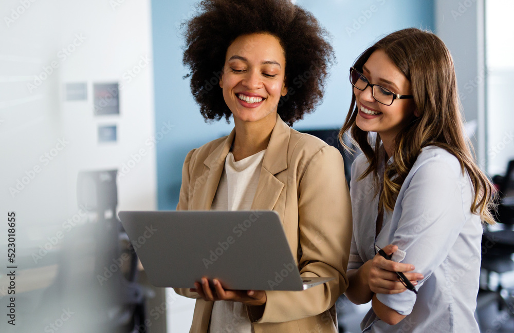 Happy multiethnic business women working together online on a laptop in ...