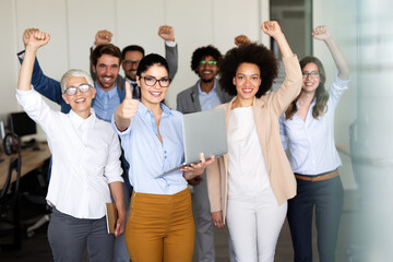 Wall Mural - Group of successful multiethnic business people celebrating a good job in the office