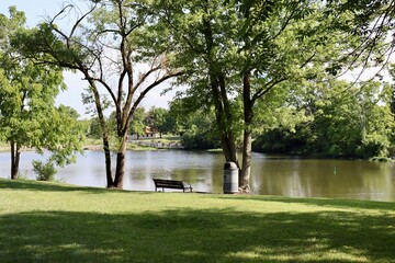 The park bench at the lake in the park.