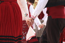 People In Traditional Folk Costume Of The National Folklore Fair In Koprivshtica. The National Folklore Fair In Koprivshtica Is Entered In The UNESCO Register Of The Human Intangible Cultural Heritage