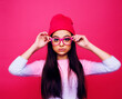 Leinwandbild Motiv young pretty girl with brunette long hair posing cheerful on pink background, lifestyle people concept