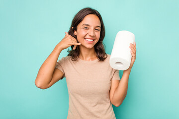 Wall Mural - Young hispanic woman holding kitchen roll isolated on blue background showing a mobile phone call gesture with fingers.