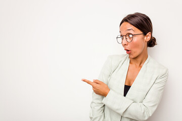 Wall Mural - Young hispanic woman isolated on white background points with thumb finger away, laughing and carefree.