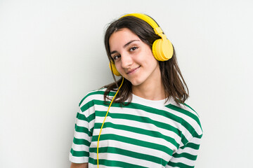 Young caucasian woman listening to music isolated on white background happy, smiling and cheerful.