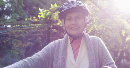 Sticker - Senior woman riding a bike, having fun and enjoying a relaxing day outside in nature alone. Portrait of one happy, smiling and cheerful retired lady getting ready for a bicycle ride in the park