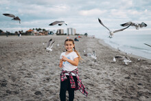Smiling Girl On The Beach Feeding Gulls 