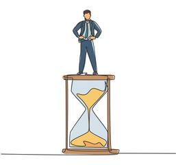 Wall Mural - Continuous one line drawing young male worker standing above hourglass. Sandglass to show time management business minimalist concept. Single line draw design vector graphic illustration