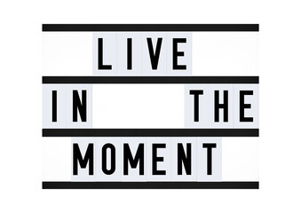 Live in the moment phrase on vintage retro quote board. Mindfulness inspirational quote