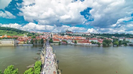 Wall Mural - Charles Bridge and Prague Castle timelapse, view from the Bridge tower, Czech Republic. Cloudy sky at sunny day