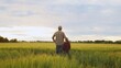 © Acronym - Farmer and his son in front of a sunset agricultural landscape. Man and a boy in a countryside field. Fatherhood, country life, farming and country lifestyle.