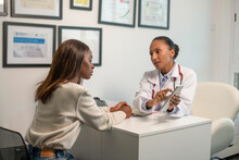 Confident Doctor Talking To Patient And Pointing At Touchpad. Young African American Woman Having Consultation In Clinic. Medical Consultation Concept