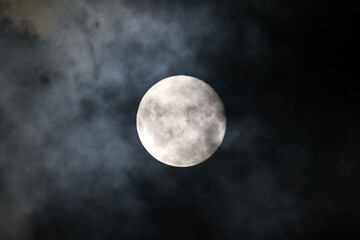 a cloudy moon in a dark night