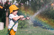 © Юлия Клюева - A little boy is playing with a garden hose in the backyard on a hot sunny day. A preschool child is watering flowers in the garden. The concept of raising a child and teaching him to work.
