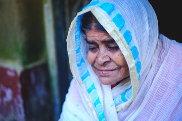 smiling face of south asian aged grandmother, Bangladeshi hindu religious woman in traditional clothes 