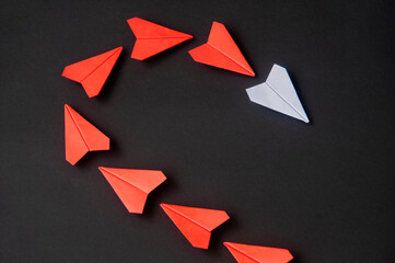 Wall Mural - White paper plane origami leading red planes on dark background. Leadership skills concept