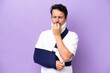 Young caucasian man wearing a sling and neck brace isolated on purple background having doubts