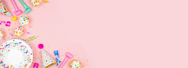 Leinwandbilder - Birthday party corner border on a pastel pink banner background. Overhead view with cakes, party hats and confetti. Copy space.