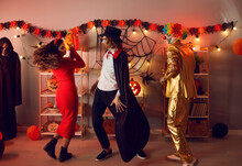 Happy Diverse People In Costumes Makeup Dance Celebrate Halloween In Decorated Home Together. Smiling Friends Have Fun On All Saints Eve Party Or Masquerade. Fall Party, Celebration Concept.