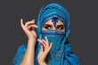© nazarovsergey - Studio shot of a young beautiful woman wearing the blue hijab decorated with sequins and jewelry. Arabic style.