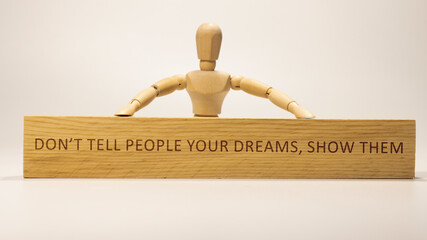 The word Don't tell people your dreams, show them was written on the wooden surface. Slogans and positive thinking