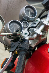 Steering wheel and dashboard of a red classic motorcycle