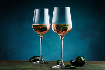 Wall Mural - Rose pink wine with jalapeno pepper in wine glass, dark background, copy space