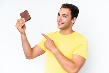 Wall Mural - Young caucasian man holding a wallet isolated on white background and pointing it