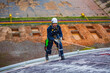 © chitsanupong - Male worker inspection wearing safety first harness rope safety line working at a high place on tank roof spherical gas  blue sky