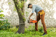 © Angelov - man sawing branches with a chainsaw. Concept of a professional logging