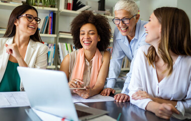 Group of happy successful women colleagues working together on meeting in corporate office