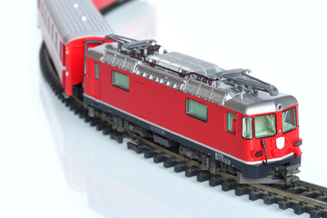 Scale toy model of red train isolated on white reflective background