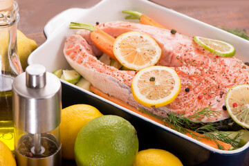 Poster - Raw fish is ready for baking. Salmon steak. Red fish and sliced lemons on white